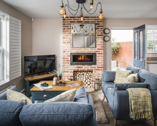 rustic living room with exposed brick modern fireplace, blue sofas, shutters