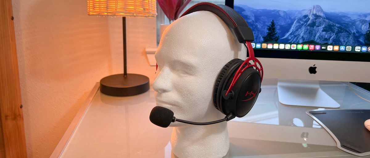 A HyperX Cloud Alpha Wireless gaming headset on a glass desk