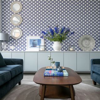 living room with graphic wallpaper and blue sofa