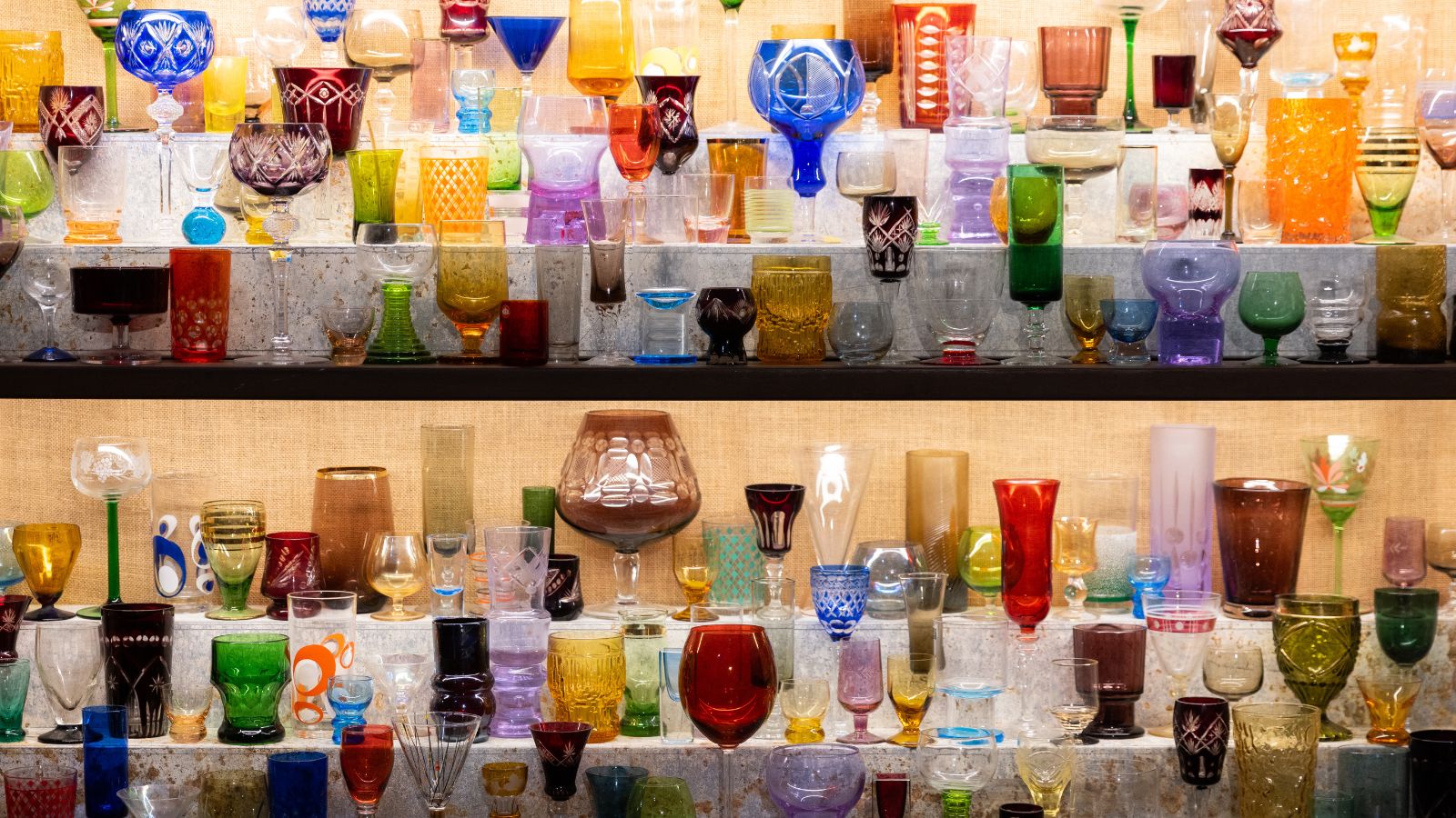 An array of coloured vintage glasses on shelves