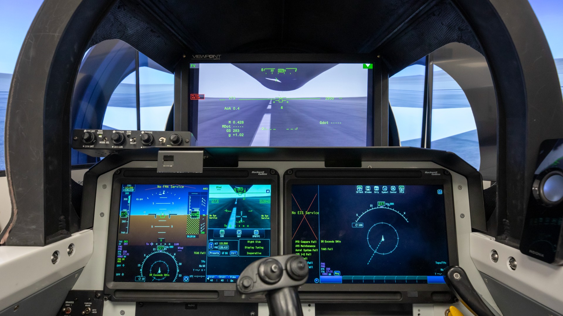 Três displays retangulares em uma cabine estreita de avião