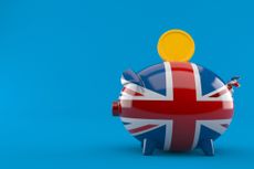 UK piggy bank with coin isolated on blue background