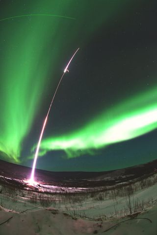 A two-stage Terrier-Black Brant rocket arced through aurora about 200 miles above Earth on the Magnetosphere-Ionosphere Coupling in the Alfvén resonator (MICA) mission to study the physics of the northern lights. Stage one of the rocket has just separated and is seen falling back to Earth in this photo taken on Feb. 18, 2012.