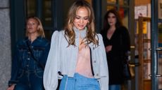 jennifer lopez wearing a grey jacket and denim trouser outfit