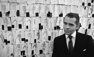 Karl Lagerfeld in front of his sketches