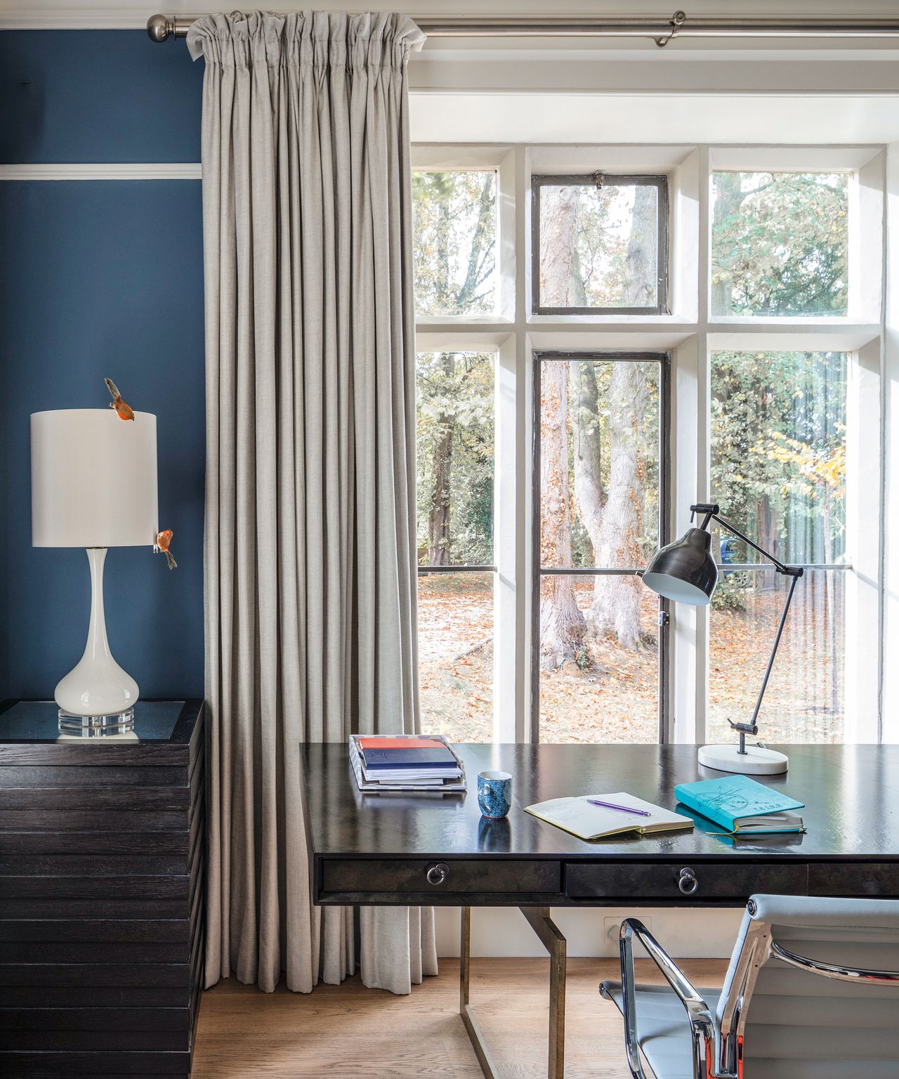 Large window curtain ideas with gray curtains in a blue study with black desk and gray chair