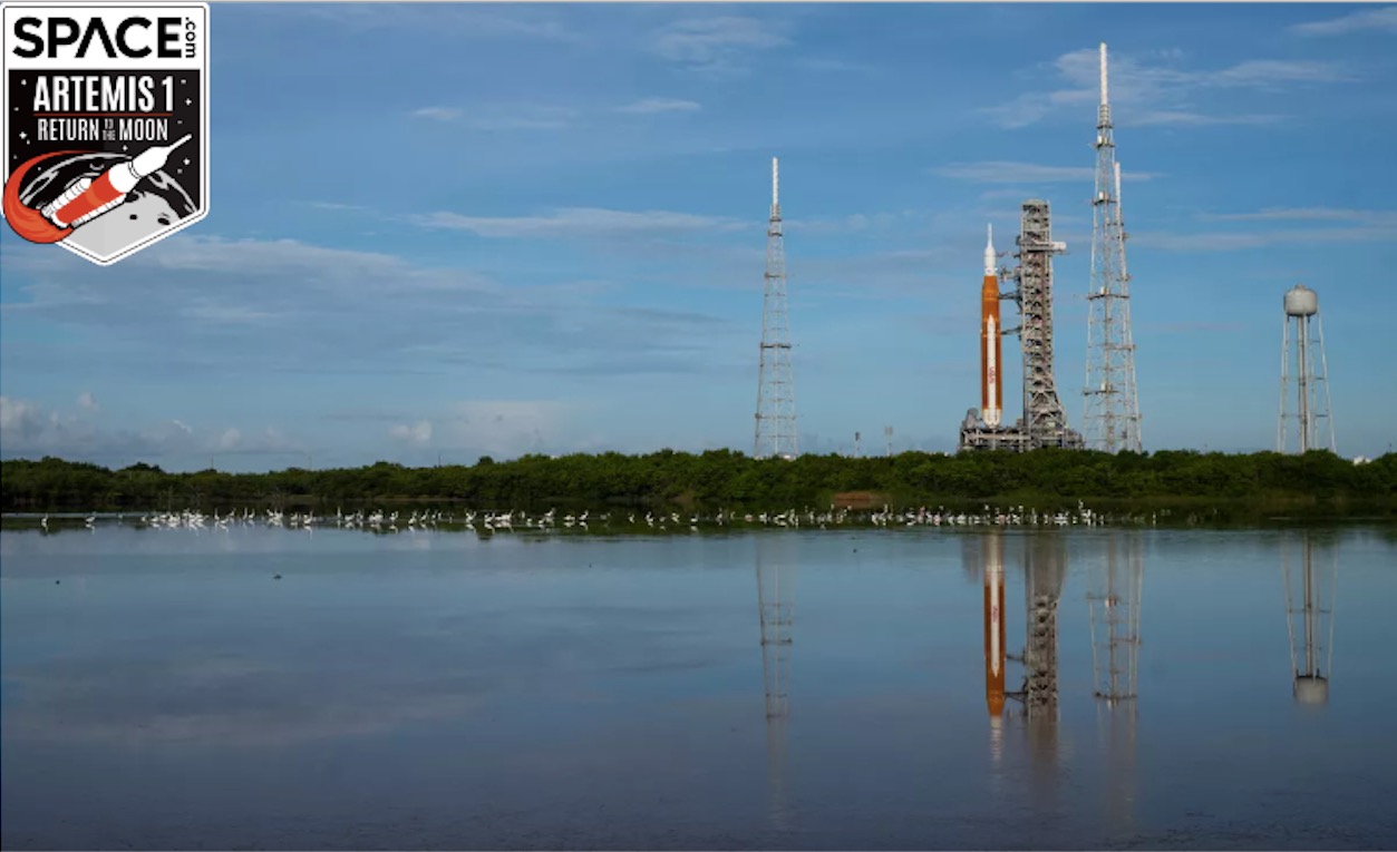 artemis 1 on a launch pad reflected by a lake