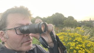 The author looking through an Opticron Explorer WA ED-R 8x42 monocular during the daytime.