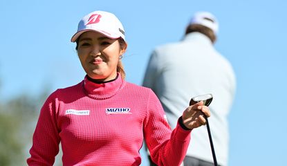 Ayaka Furue smiles as she walks off the green with her putter in hand