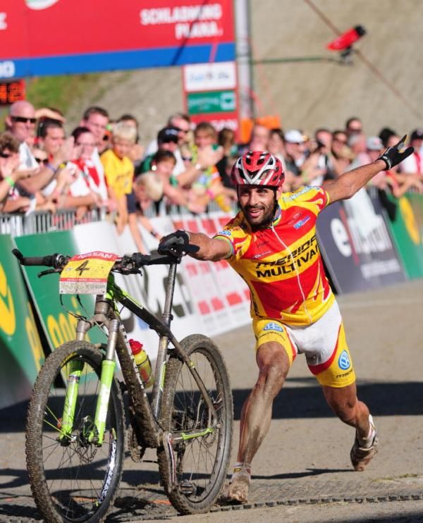 Jose Antonio Hermida Ramos (Merida Multivan) throws his bike over the line