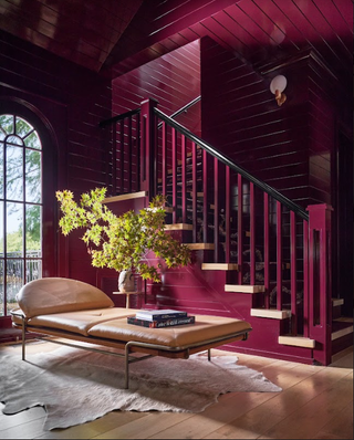 A red toned staircase with a tan color daybed