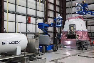 COTS 2 Demo Dragon undergoing launch prep at SpaceX hangar in Cape Canaveral.