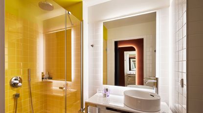a small bathroom with a yellow painted shower