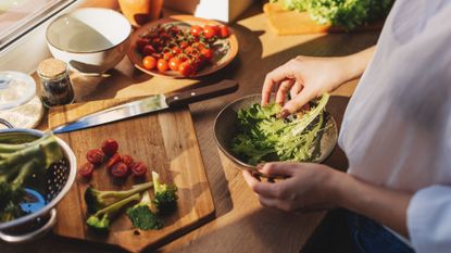 Women preparing salad with some of the best foods to have in the evening, including leafy green vegetables