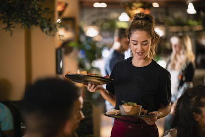 Waitress serving customers food at a restaurant 