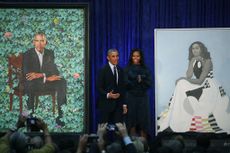 Barack and Michelle Obama with their official portraits.