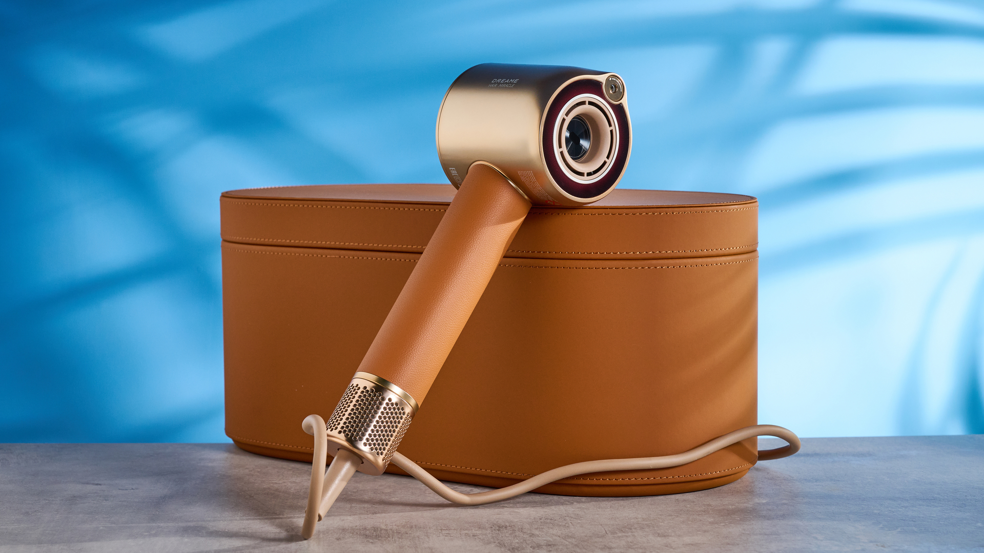 the dreame miracle pro hair dryer in gold showing the storage box on the blue tom's guide background, with the four attachment nozzles including two blow-drying nozzles, diffuser, and the flyaway tamer