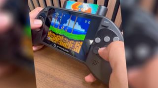 Hands using Hyperkin Mega85 handheld to play Sonic the Hedgehog 2 Sega Genesis cartridge. 