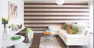 White living room with a striped wall in brown and white striped wallpaper to ask can you paint over wallpaper