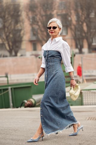Grece Ghanem is seen wearing a white shirt, long denim maxi dress, and beige bag outside Sportmax during the Milan Fashion Week Womenswear Fall/Winter 2023/2024 on February 24, 2023 in Milan, Italy.