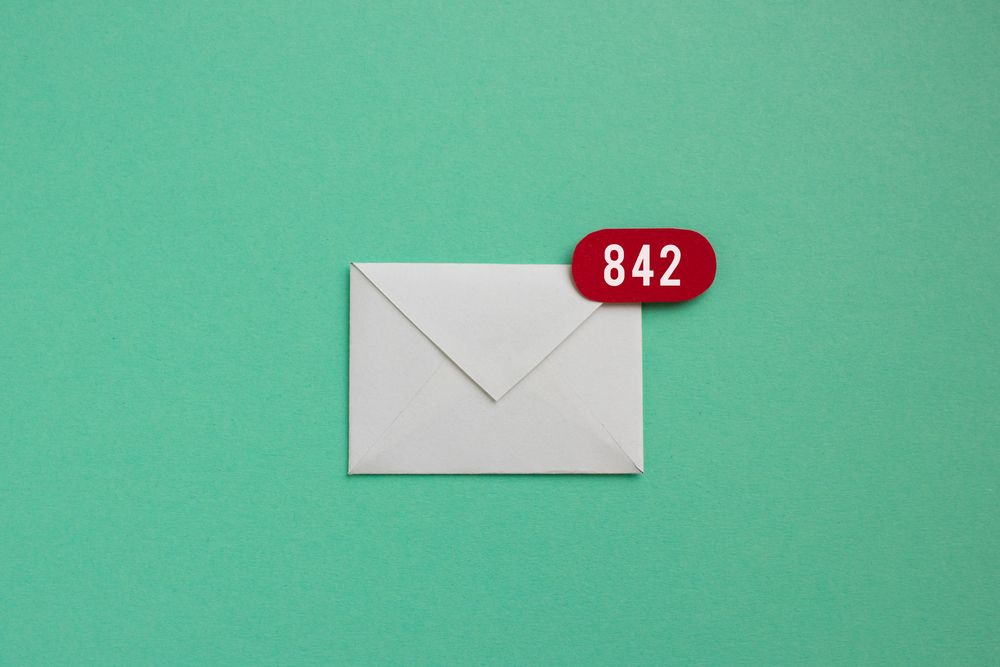 Minimalist design of an envelope with red notification badges symbolising emails, against a powder green background