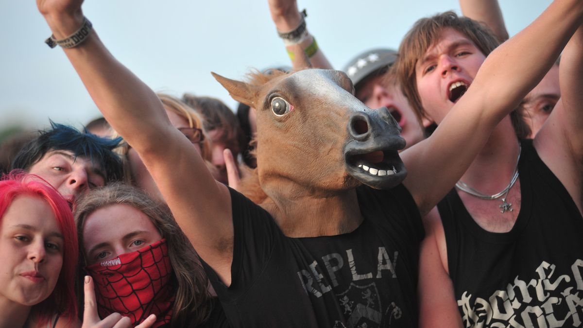 A person in a horse mask among a crowd of young people