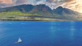 Sail boat in ocean with Hawaii in background