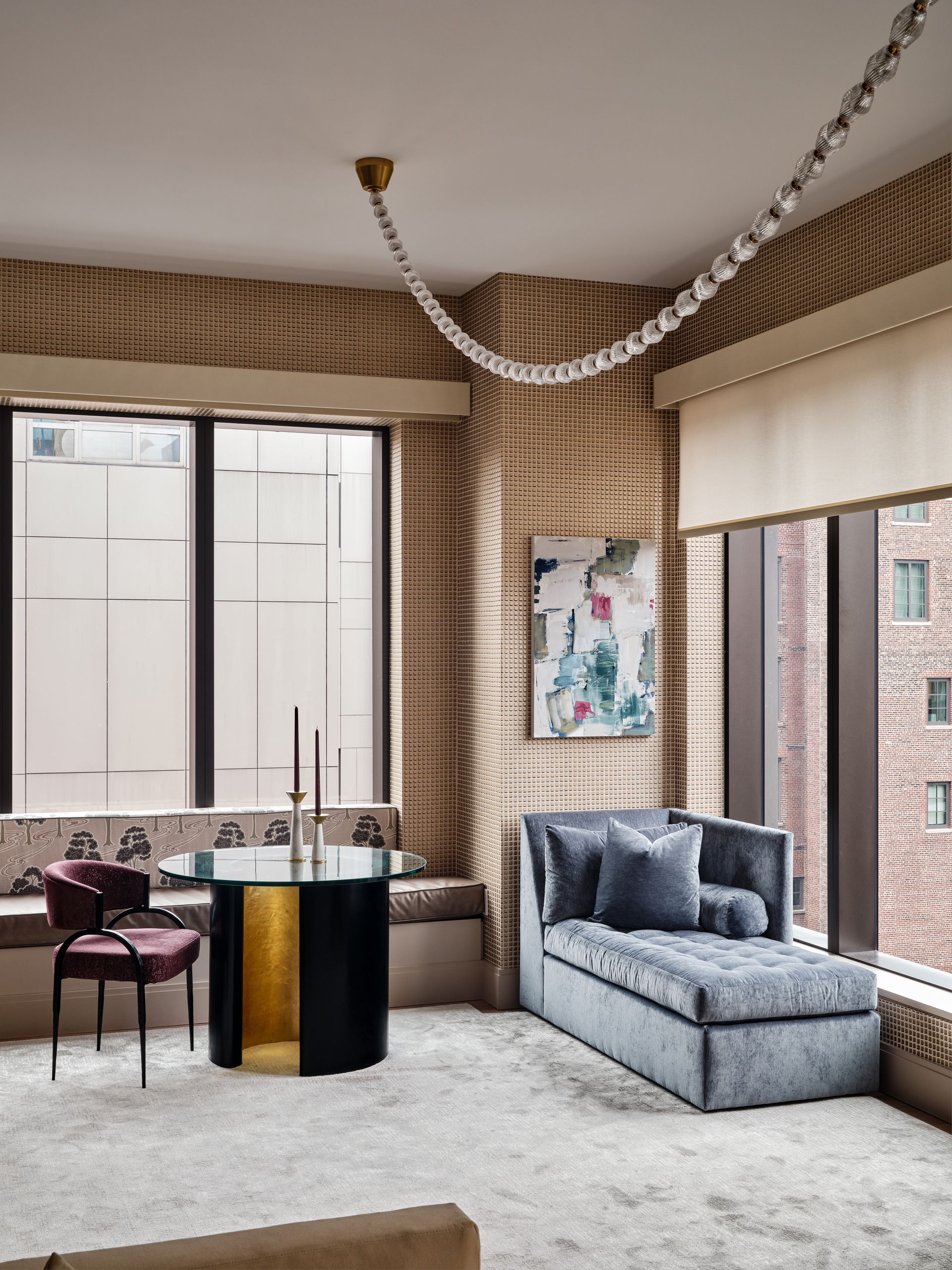 A living room with a blue chaise longue and a statement string light pendant overhead