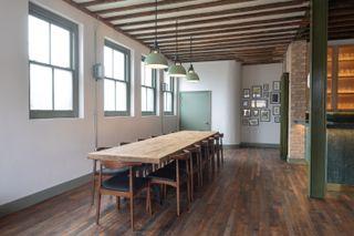 long meeting table on a wooden floor in thames distillers new home in London