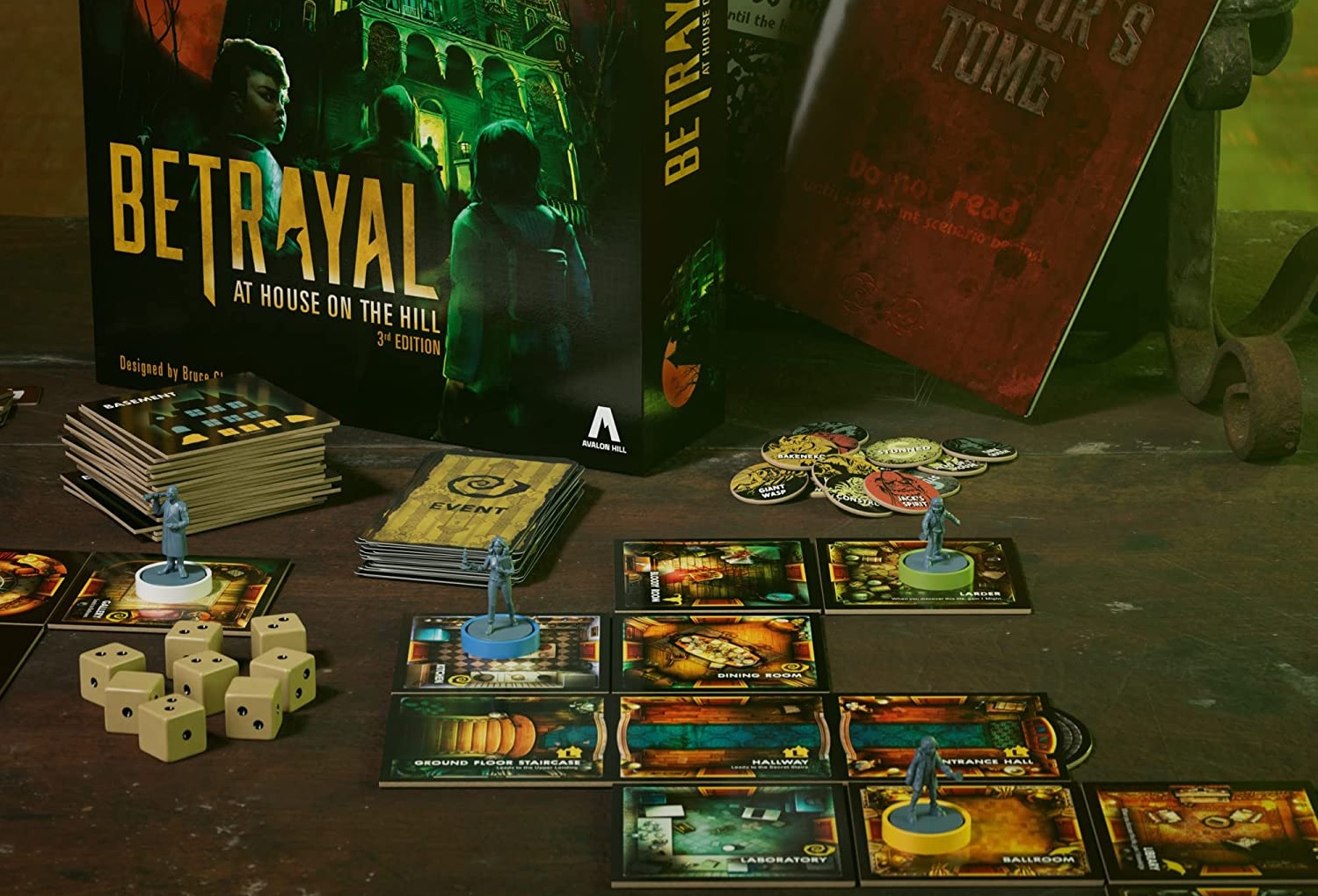 Sällskapsspelet Betrayal at House on the Hill med dess kort, figurer och tärningar ligger utplacerade på ett mörkt bord.