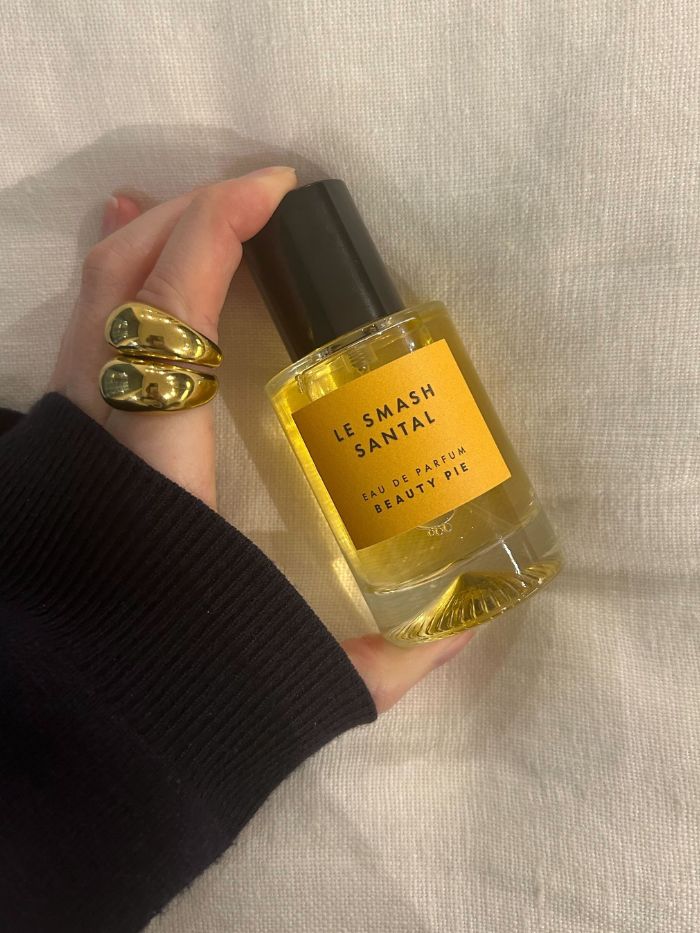 Junior beauty editor Grace Lindsay holding a Beauty Pie perfume on a white linen background