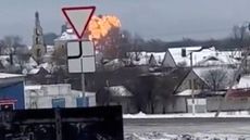 Handout photo taken from validated UGC video show flames rising from the scene of a warplane crashed at a residential area near Yablonovo, Belgorod region