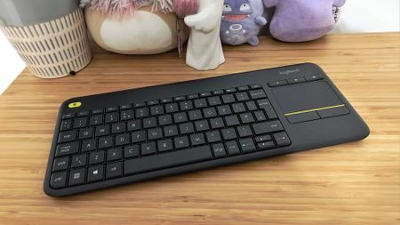 Logitech K400 Plus keyboard sitting on woodgrain surface