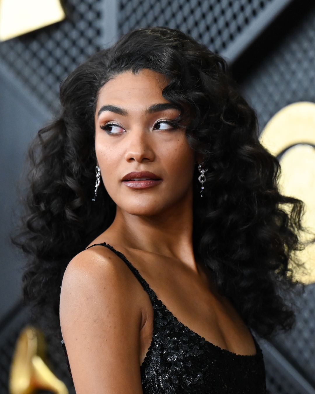 Olivia Dean with frosted eye makeup and bouncy curls at the 2026 Grammy Awards