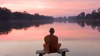 men meditating looking at a lake