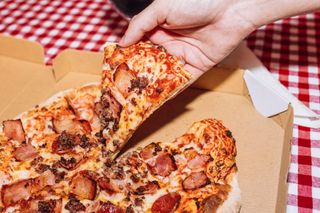 Man holding pizza slice