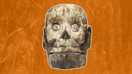 front aspect of a wood mask carved like a skull from the Aztec culture