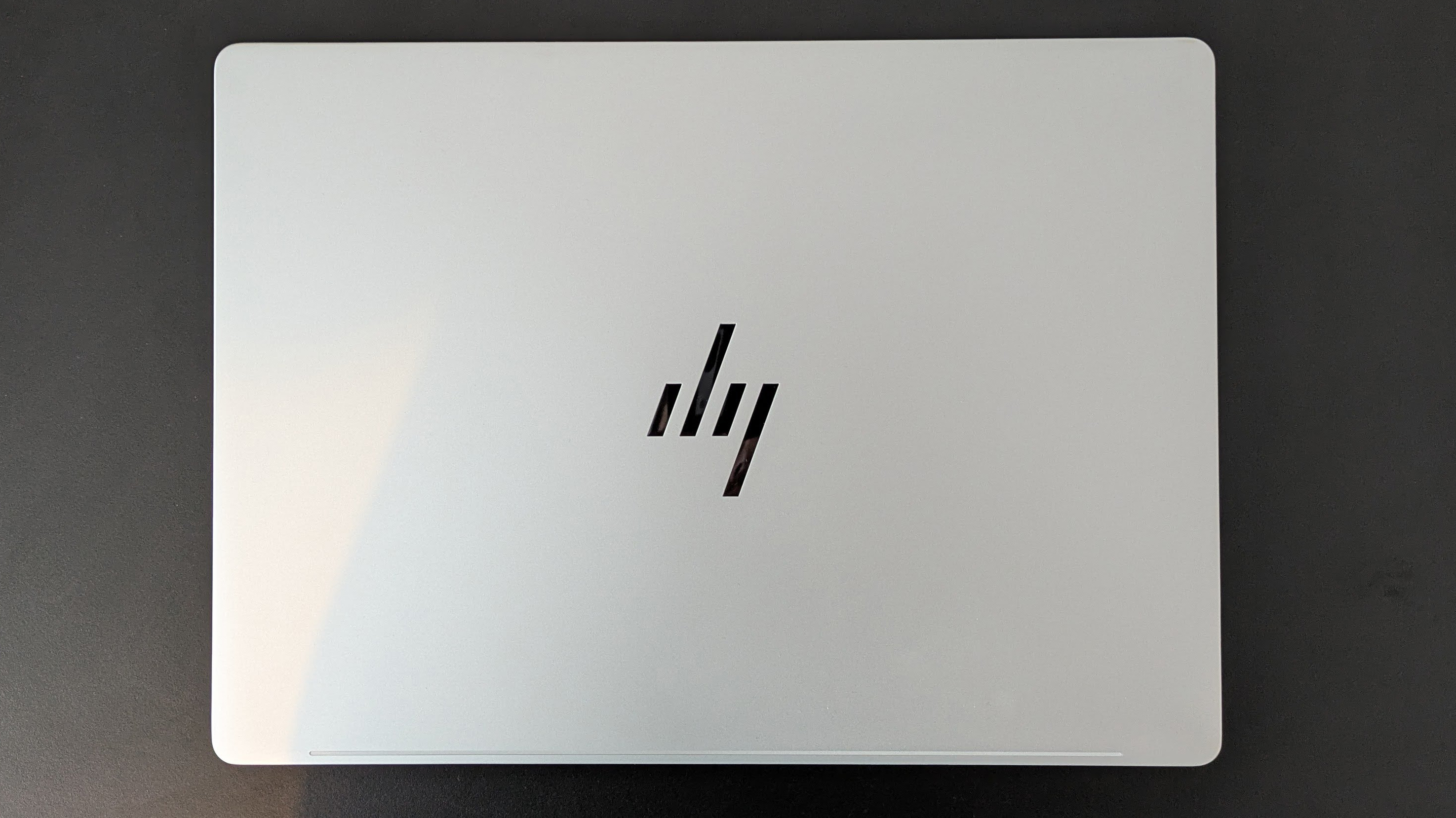 Top-down view of HP OmniBook 7 14-inch closed on black desk