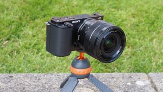 A Sony ZV-E10 pictured in front of grass, one of the best cheap cameras