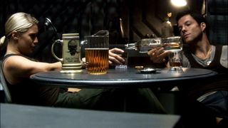 A blonde woman and a brown-haired man sat a a table drinking beer.