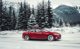 Red car of Tesla on snowy road