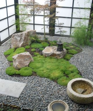 A screened off rock garden with moss and gravel