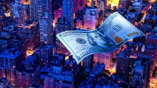 Conceptual image of American one hundred dollar bill flying across a city nightscape