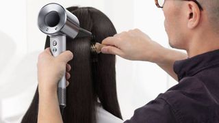A hairdresser drying long dark hair
