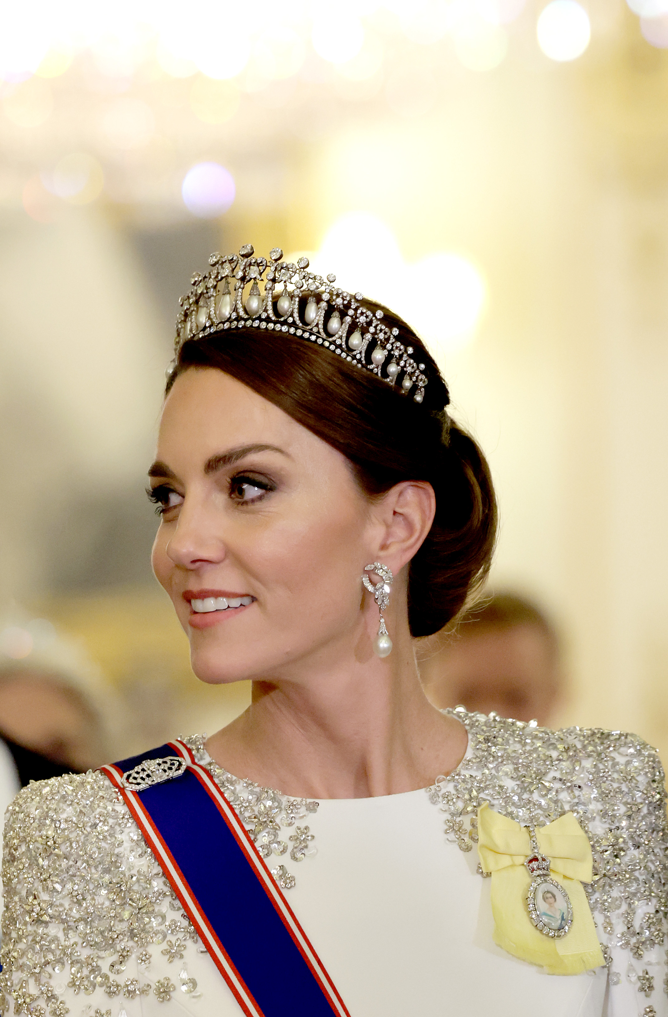 Princess Kate wearing the Lover's Knot Tiara and a white gown with silver shoulder detail