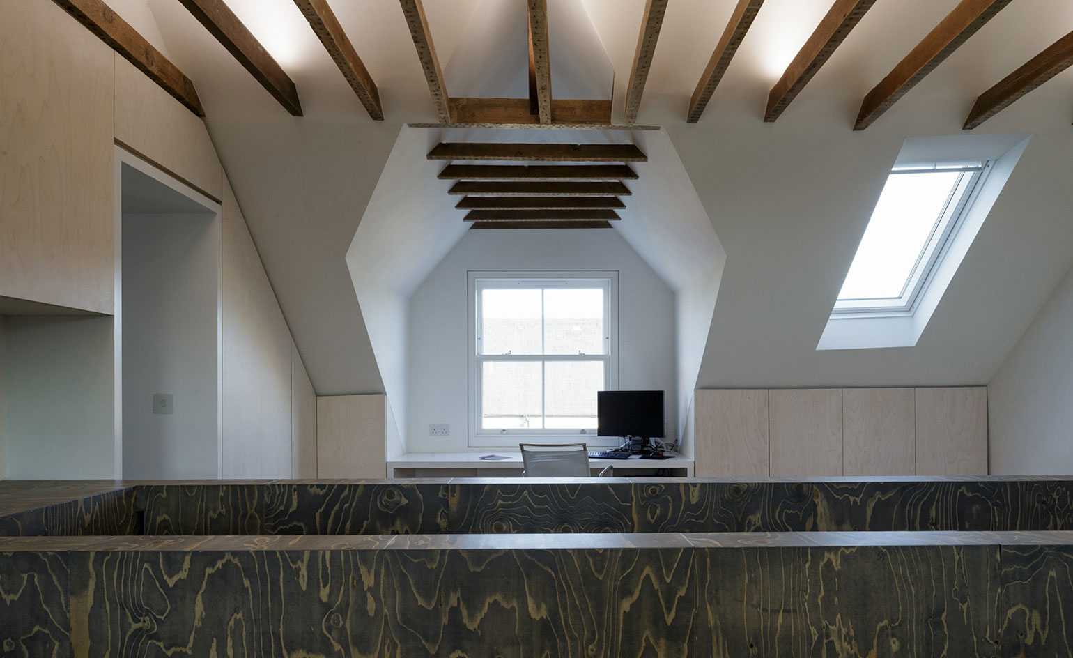 Top of staircase in room with exposed beams