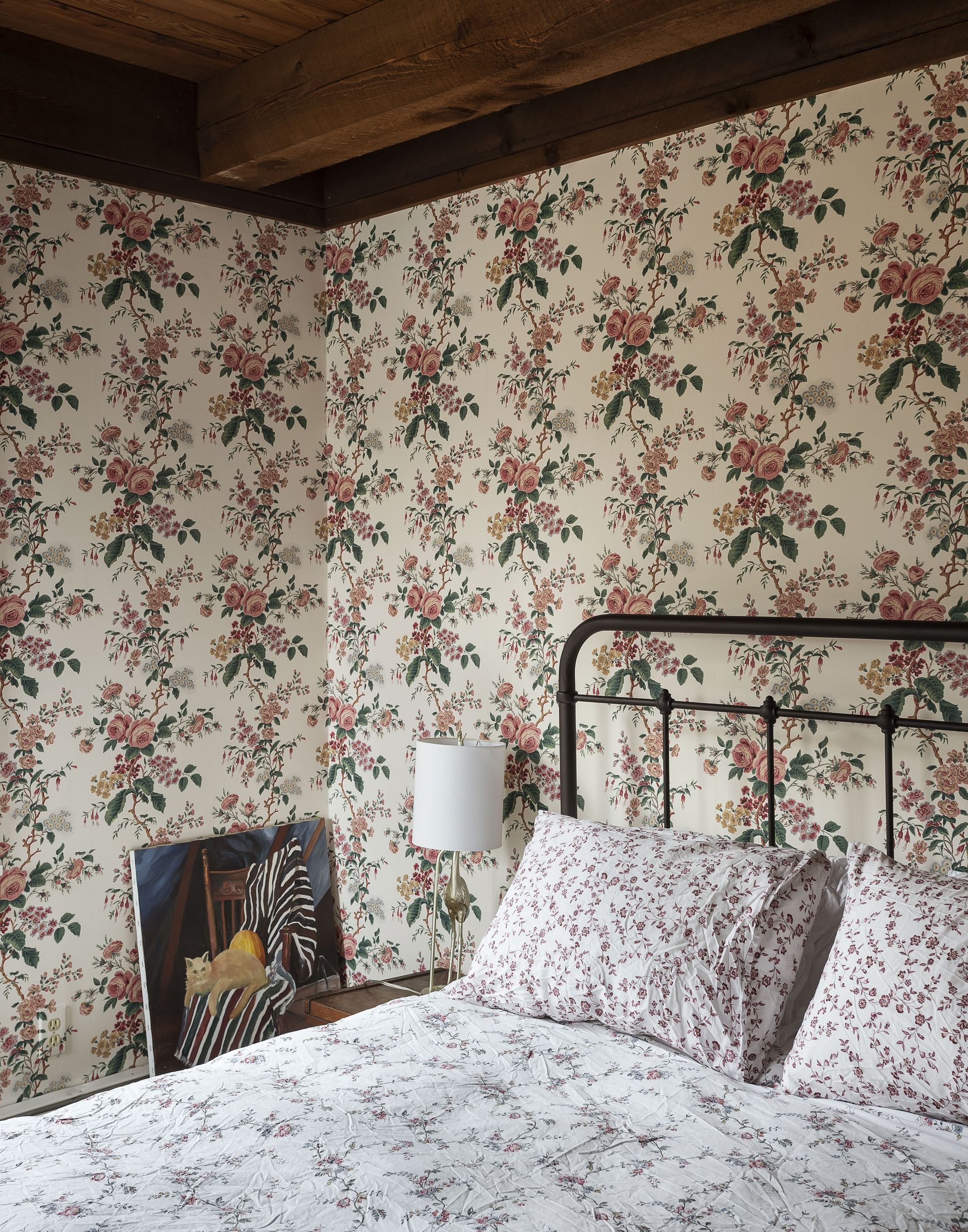A bedroom with a wooden ceiling and brown toned wallpaper