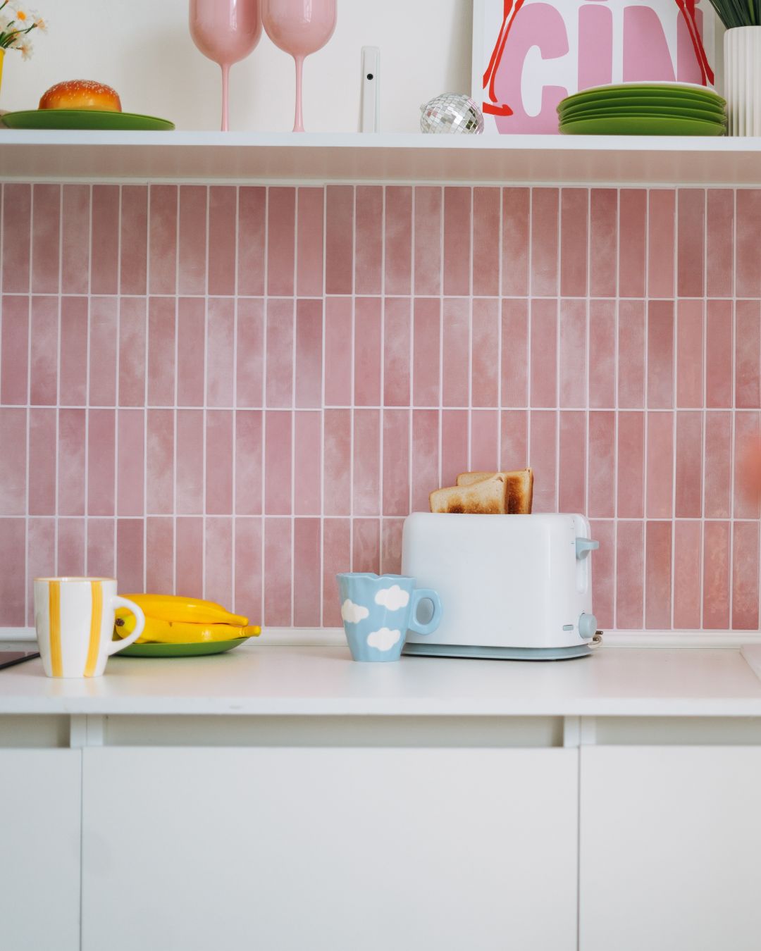 kitchen with pink splashback and white counter