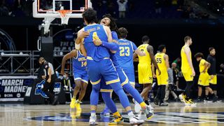 Tyger Campbell #10 of the UCLA Bruins celebrates with Jaime Jaquez Jr. #4 after defeating the Michigan Wolverines 51-49 in the Elite Eight round game of the 2021 NCAA Men's Basketball Tournament at Lucas Oil Stadium on March 30, 2021 in Indianapolis, Indiana.