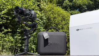 DJI RS 3 Pro and case outside in front of a bush